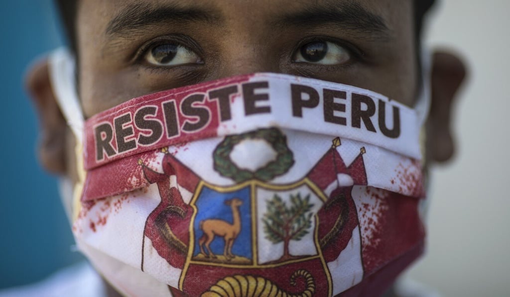 John Sanchez wears a face mask with the Spanish message “Resist Peru” as he waits in line to be tested for Covid-19 at a hospital in Lima in April. Photo: AP