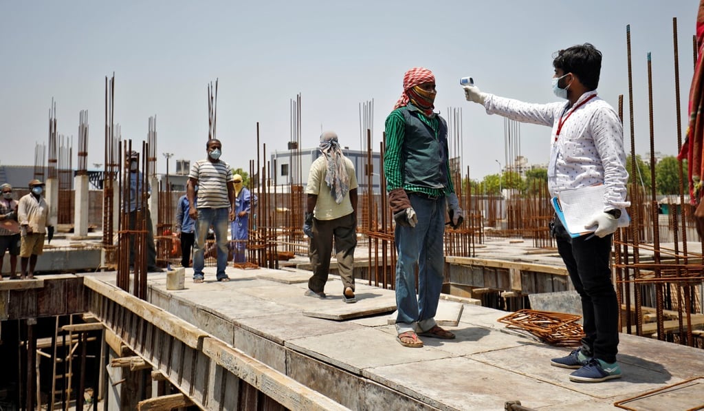 A health worker checks the temperature of a labourer in Ahmedabad, India. Photo: Reuters