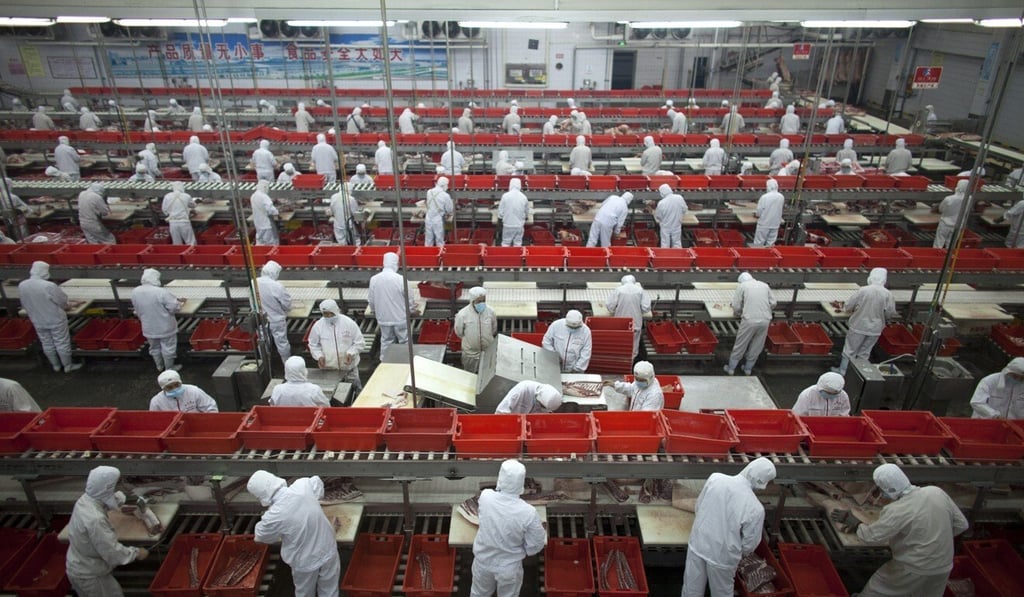 Employees work on production lines at a pork processing plant owned by WH Group in central Henan province in China. Photo: AP