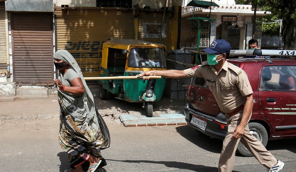 A policeman in Ahmedabad, India, uses his baton to push a resident breaking rules during the country’s extended lockdown. Photo: Reuters A policeman in Ahmedabad, India, uses his baton to push a resident breaking rules during the country’s extended lockdown. Photo: Reuters
