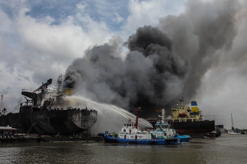 Fire fighters try to extinguish a fire on a tanker ship docked in Belawan on May 11, 2020. Photo: AFP