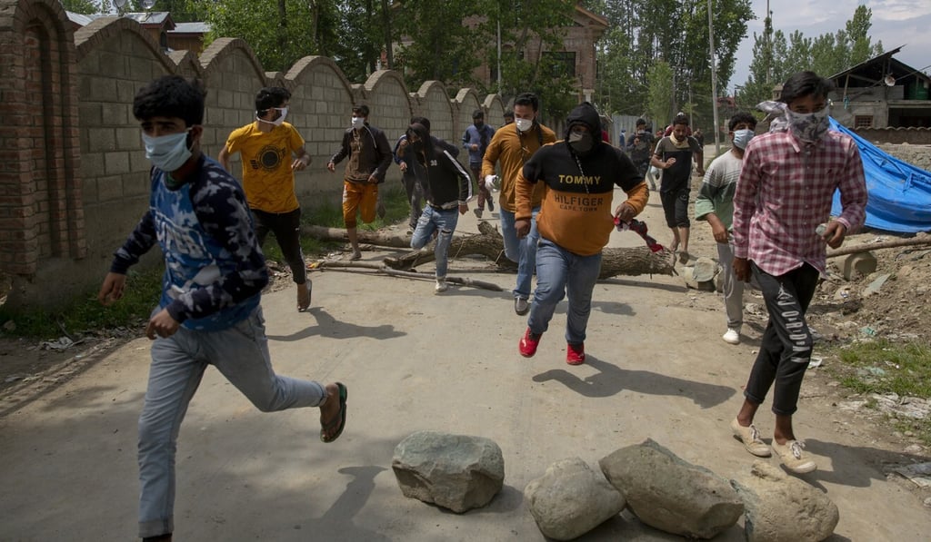 Kashmiri villagers run for cover as policemen chase after firing tear gas during a protest on May 13, 2020. Photo: AP Kashmiri villagers run for cover as policemen chase after firing tear gas during a protest on May 13, 2020. Photo: AP