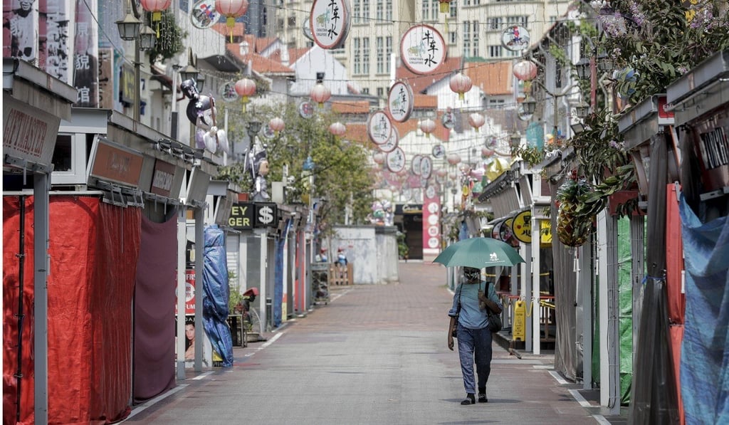 A woman walks past closed stores in the Chinatown district in Singapore. Photo: EPA-EFE A woman walks past closed stores in the Chinatown district in Singapore. Photo: EPA-EFE