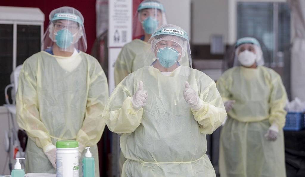 Medical workers wearing personal protective equipment are seen at a foreign worker dormitory in Singapore. Photo: EPA-EFE