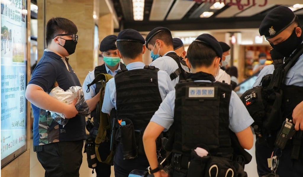Police officers stop and search a man as anti-government protesters gather at New Town Plaza in Sha Tin. Photo: Winson Wong