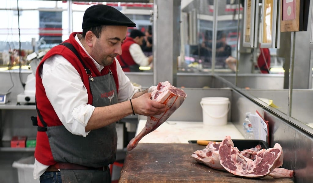 A butcher cuts up a leg of Australian lamb at his store in Melbourne on May 12, 2020. Photo: AFP