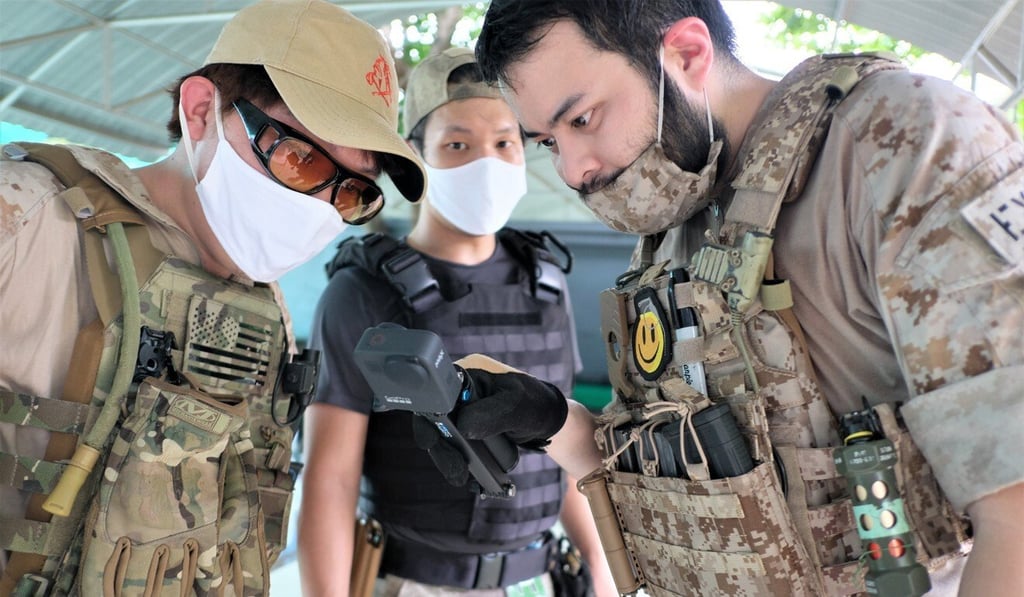 Sutipatt Sudhisanronakorn (right) and Apichai Karnjanakantika (left) watch a replay of their military-style training session. Both are kitted out in Chinese-made knock-off US military uniforms. Photo: Tibor Krausz