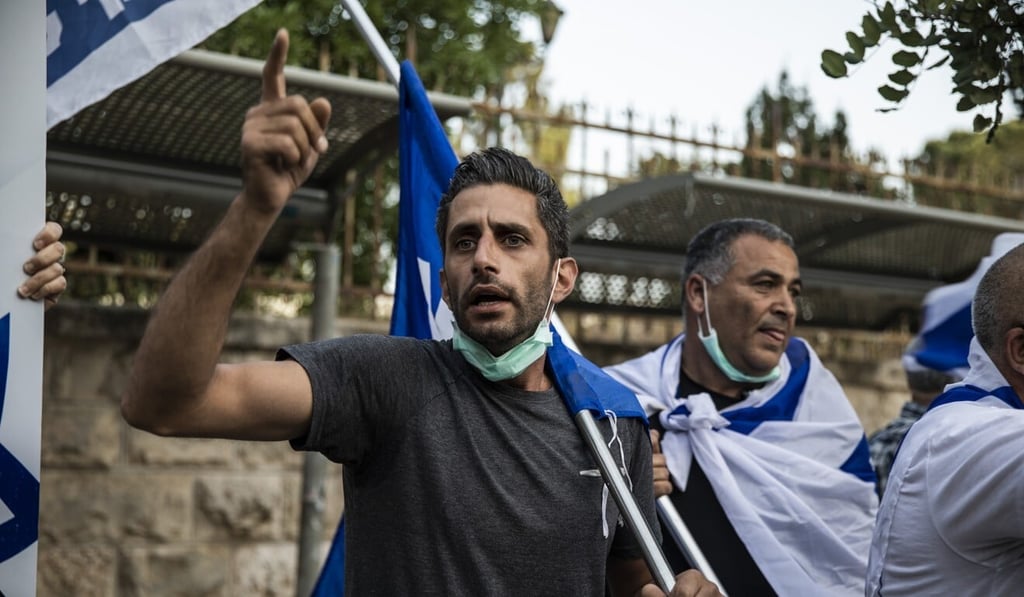 A protester wearing a face mask takes part in a demonstration against the forming of the new Israeli government, led by leader of the Likud party Benjamin Netanyahu and leader of the Blue and White party Benny Gantz, outside Israeli Prime Minister Netanyahu’s Residency. Photo: dpa A protester wearing a face mask takes part in a demonstration against the forming of the new Israeli government, led by leader of the Likud party Benjamin Netanyahu and leader of the Blue and White party Benny Gantz, outside Israeli Prime Minister Netanyahu’s Residency. Photo: dpa