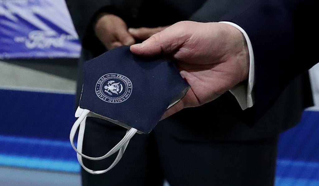 US President Donald Trump holds a face mask with a presidential seal on it at the Ford Rawsonville Components Plant in Michigan on Thursday. Photo: Reuters