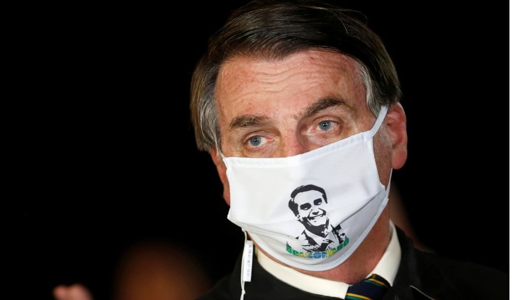 Brazil's President Jair Bolsonaro speaks with journalists while wearing a protective face mask. Photo: Reuters Brazil's President Jair Bolsonaro speaks with journalists while wearing a protective face mask. Photo: Reuters