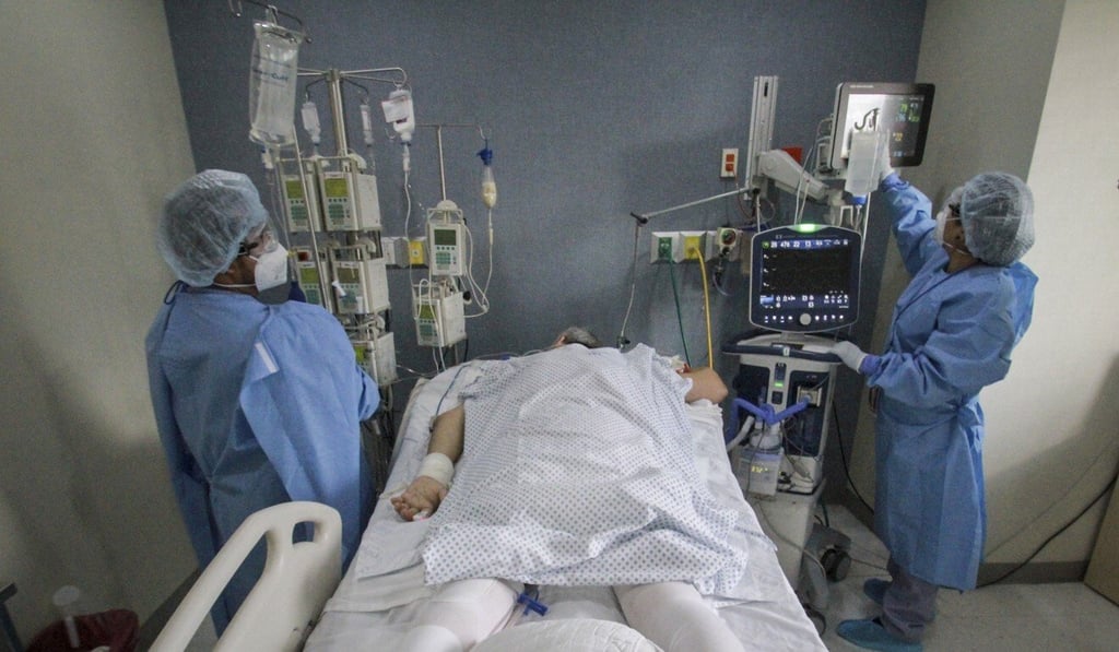 Dr Miguel Vazquez, left, and a medical worker, check the current status of a new coronavirus patient, in Tijuana, Mexico. Photo: AP Photo