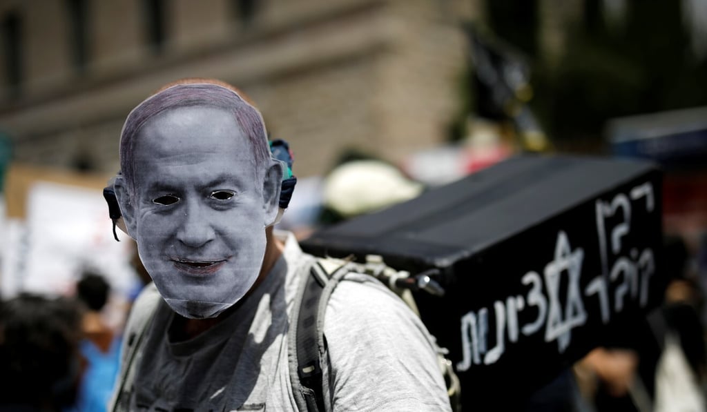 A protester wearing a mask depicting Israeli Prime Minister Benjamin Netanyahu takes part in a demonstration against Netanyahu just before his corruption trial opens. Photo: Reuters A protester wearing a mask depicting Israeli Prime Minister Benjamin Netanyahu takes part in a demonstration against Netanyahu just before his corruption trial opens. Photo: Reuters