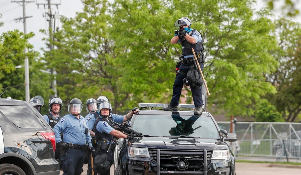 A police officer aims at protesters gathered near the Minneapolis Police third precinct. Photo: Reuters