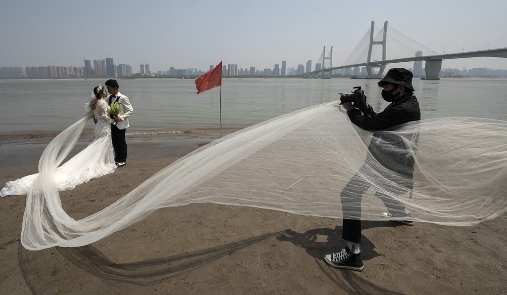A couple poses for wedding photos on the bank of the Yangtze River in Wuhan in April. Photo: Xinhua A couple poses for wedding photos on the bank of the Yangtze River in Wuhan in April. Photo: Xinhua