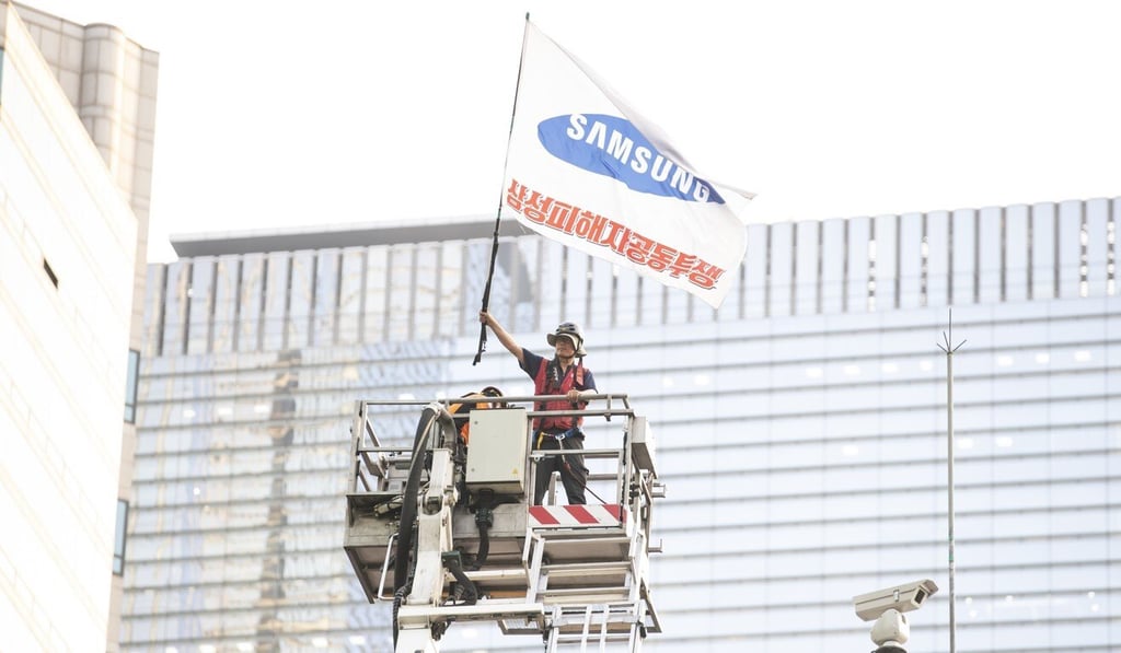 Kim Yong-hee, a fired Samsung worker, comes down from a traffic camera tower after he ended a 355-day sit-in. Photo: DPA Kim Yong-hee, a fired Samsung worker, comes down from a traffic camera tower after he ended a 355-day sit-in. Photo: DPA