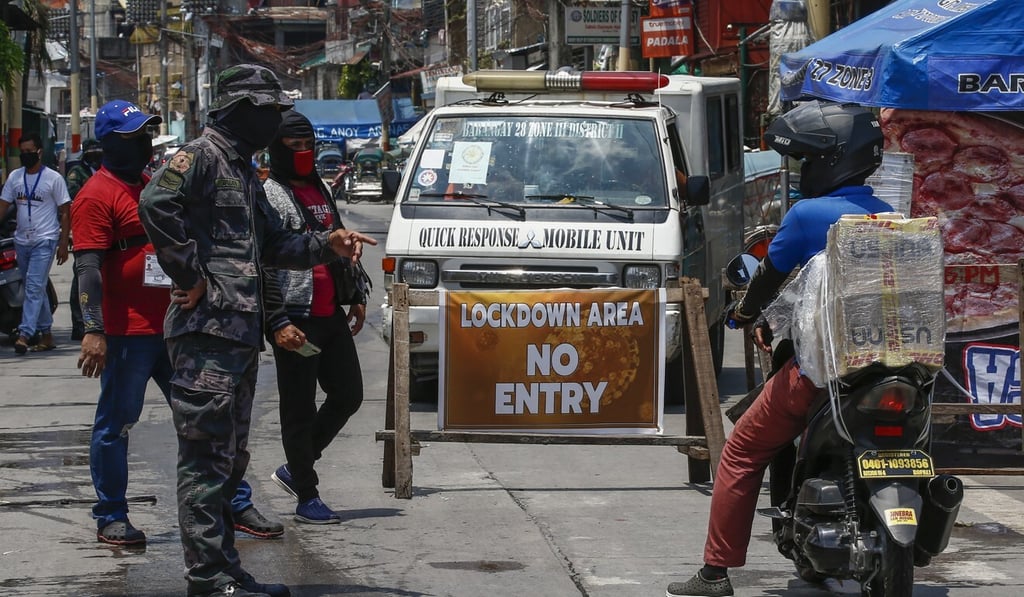 A police officer questions a delivery service worker at a checkpoint in Caloocan City, Metro Manila. Photo: EPA-EFE A police officer questions a delivery service worker at a checkpoint in Caloocan City, Metro Manila. Photo: EPA-EFE