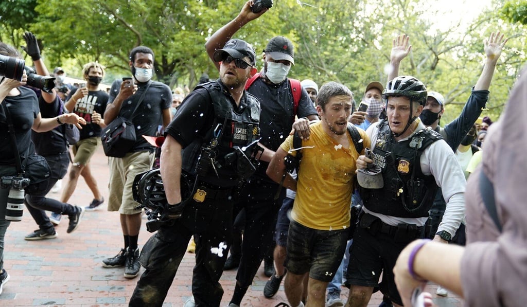 Uniformed US Secret Service police detain a protester in Lafayette Park across from the White House on Friday. Photo: AP Uniformed US Secret Service police detain a protester in Lafayette Park across from the White House on Friday. Photo: AP