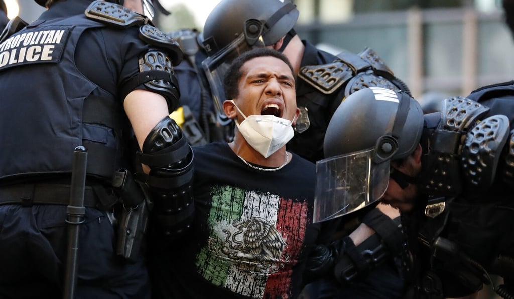 A demonstrator taken into custody by police near the White House in Washington. Photo: AP A demonstrator taken into custody by police near the White House in Washington. Photo: AP