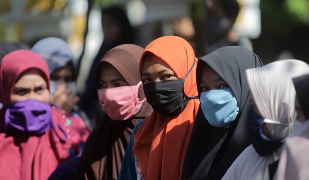 Indonesian women queue for food supplies at a flash market run by the Aceh government to help the community during the coronavirus outbreak. Photo: EPA Indonesian women queue for food supplies at a flash market run by the Aceh government to help the community during the coronavirus outbreak. Photo: EPA