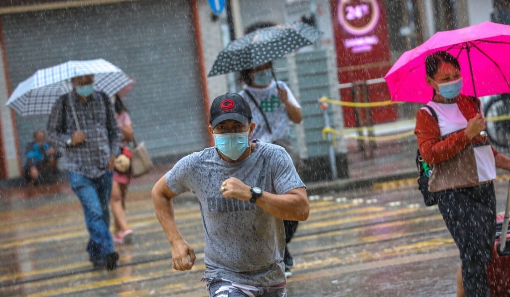 A man without an umbrella dashes across the road during heavy rain in Yuen Long. Photo: K.Y. Cheng