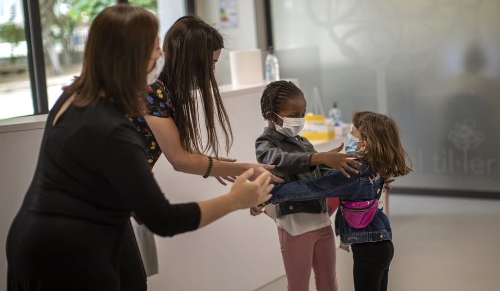 Teachers try to prevent two 6-year-olds hugging as they meet during the first day of school after the lockdown in Barcelona, Spain, on Monday. Photo: AP