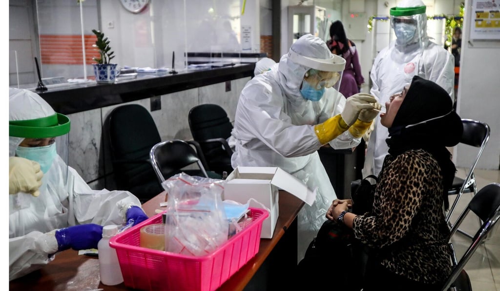 A medical worker collects swab samples to test for coronavirus in North Sumatra, Indonesia, on Wednesday. Photo: EPA