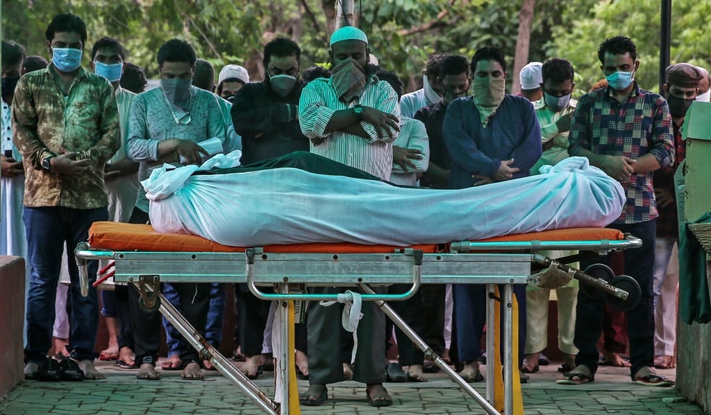 Relatives pray before the burial of a Covid-19 victim at Bada Qabrastan graveyard, in Mumbai, India. Photo: EPA-EFE
