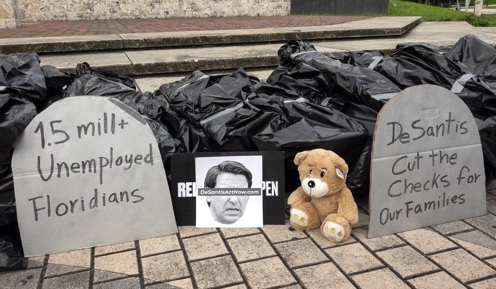Protesters displayed 100 bags, representing dead bodies, and a photo of Florida's Governor Ron DeSantis, during the protest in Miami in May against the economy reopening without coronavirus relief. Photo: EPA-EFE