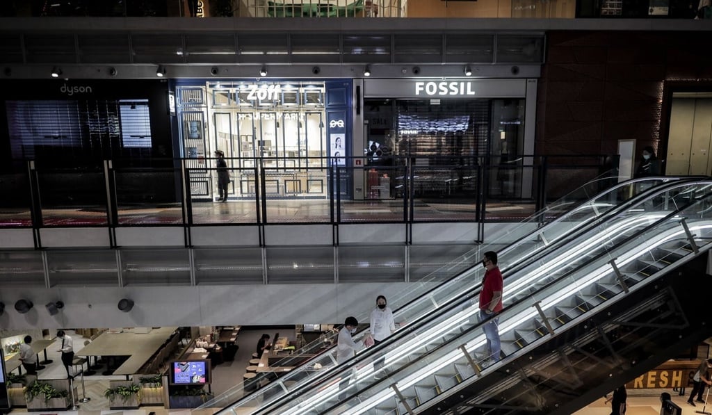 People pictured on an escalator in front of closed stores inside the Funan shopping centre in Singapore on Tuesday. Photo: EPA People pictured on an escalator in front of closed stores inside the Funan shopping centre in Singapore on Tuesday. Photo: EPA