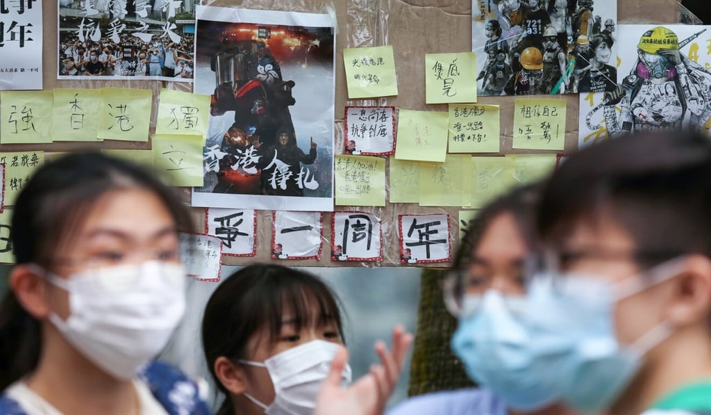 Notes marking the first anniversary of protests are seen behind students at a ‘Lennon Wall’ on Hiu Ming Street in Kwun Tong. Photo: Nora Tam Notes marking the first anniversary of protests are seen behind students at a ‘Lennon Wall’ on Hiu Ming Street in Kwun Tong. Photo: Nora Tam