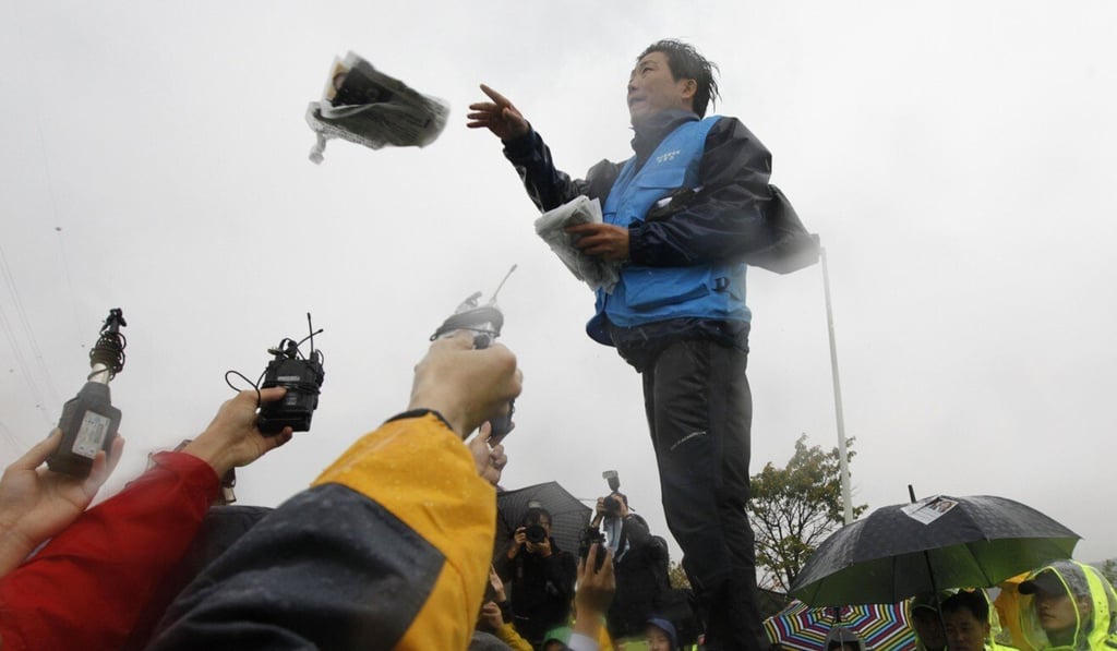 Park Sang-hak scatters anti-North Korean leaflets as he speaks to the media from the roof of a car in 2012. Photo: Reuters Park Sang-hak scatters anti-North Korean leaflets as he speaks to the media from the roof of a car in 2012. Photo: Reuters