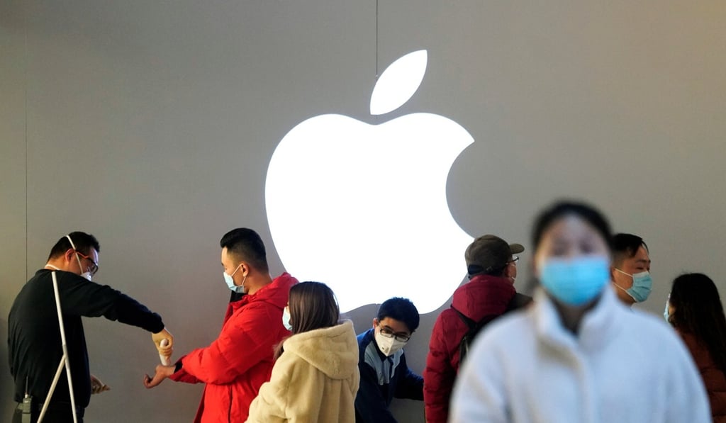 A woman in a face mask walks past an Apple store in February while it was temporarily closed because of the coronavirus pandemic. (Picture: AP) A woman in a face mask walks past an Apple store in February while it was temporarily closed because of the coronavirus pandemic. (Picture: AP)