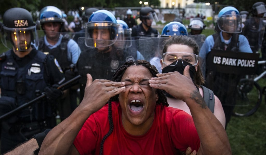 A woman reacts to being hit with pepper spray in Lafayette Square near the White House on June 22, 2020 in Washington. Photo: Tasos Katopodis/Getty Images/AFP