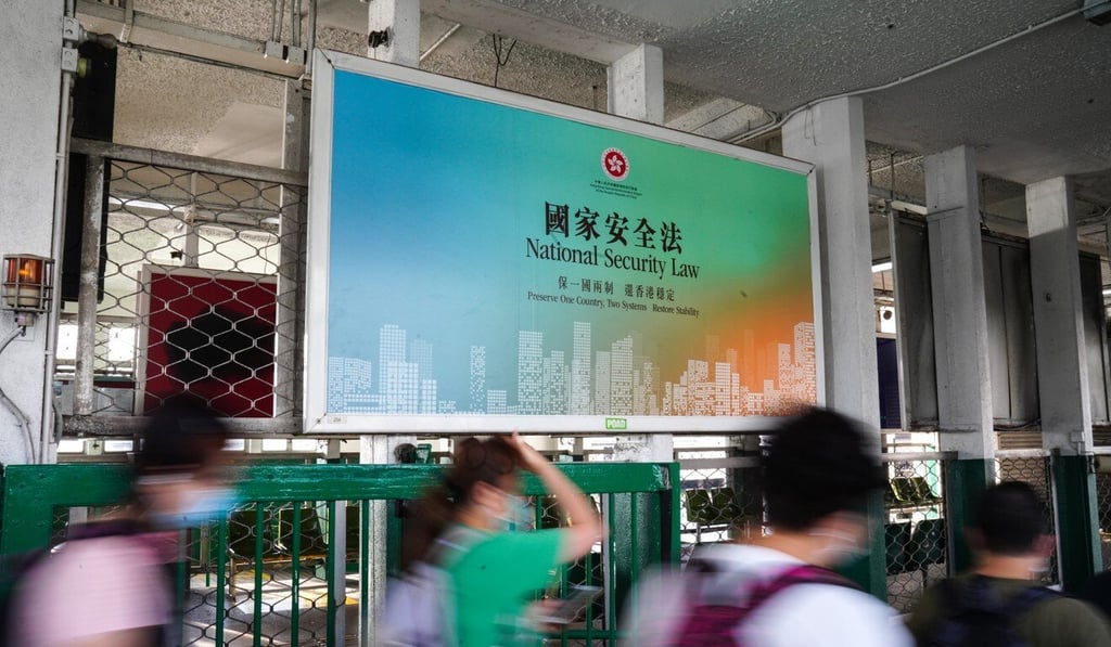 Commuters walk past a large banner promoting the national security law at the Star Ferry Pier in Tsim Sha Tsui. Photo: Sam Tsang