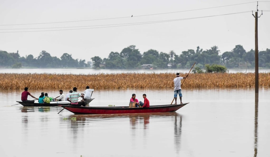 Villagers travel on boats to cross floodwaters in Assam, India, north of Bangladesh. Photo: AFP
