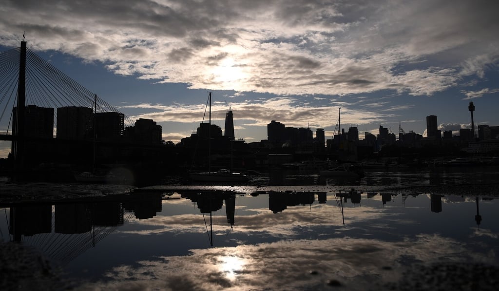 The sun rises behind the central business district in Sydney on June 29. Photo: EPA