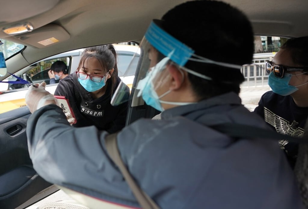 A passenger scans the QR code while doing a health check on a taxi driver at Hankou railway station in Wuhan, Hubei province. Photo: Xinhua