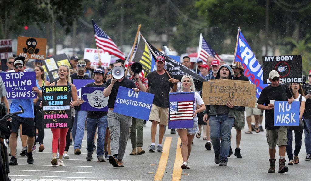 Demonstrators march through downtown Sanford, Florida on July 1 to protest against an order requiring people to wear masks in response to the spike in coronavirus cases. Photo: Orlando Sentinel via AP