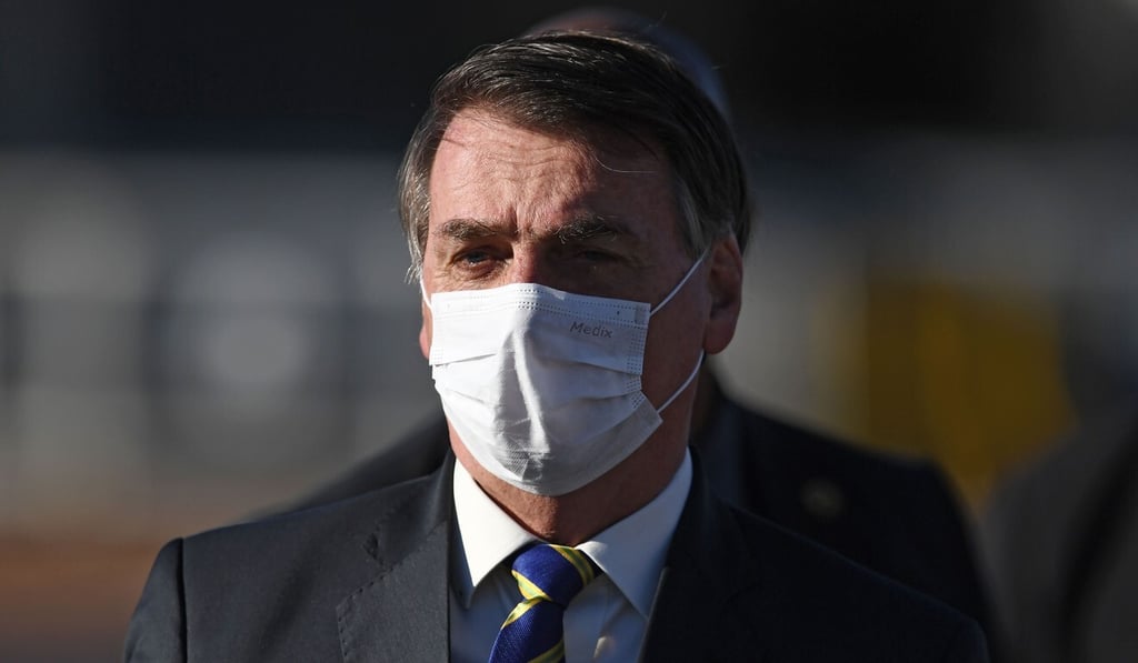 Brazilian President Jair Bolsonaro wears a face mask as he arrives at the flag-raising ceremony at Alvorada Palace in Brasilia in May. Photo: AFP