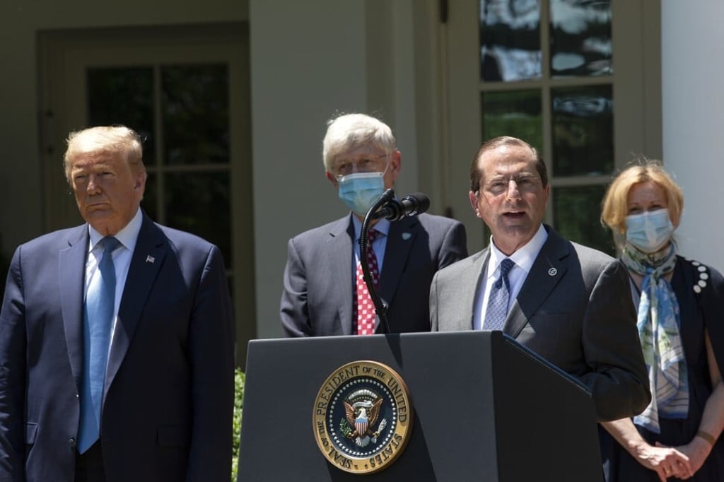 Alex Azar, secretary of Health and Human Services (HHS), speaks while President Trump listens during an event at the White House. Photo: CNP/Bloomberg