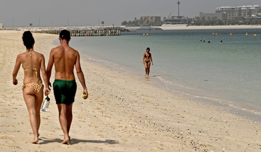 Tourists walk on the beach at the Mandarin Oriental Jumeira last week. Photo: AFP