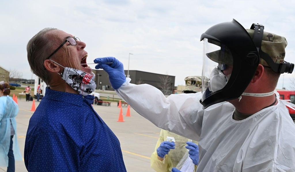 Major Preston Schaffner, of the 81st Civil Support Team, takes a swab sample from Scott Hennen, an asymptomatic volunteer, for a Covid-19 test in the car park of the FargoDome in Fargo, North Dakota on April 25. Photo: AFP