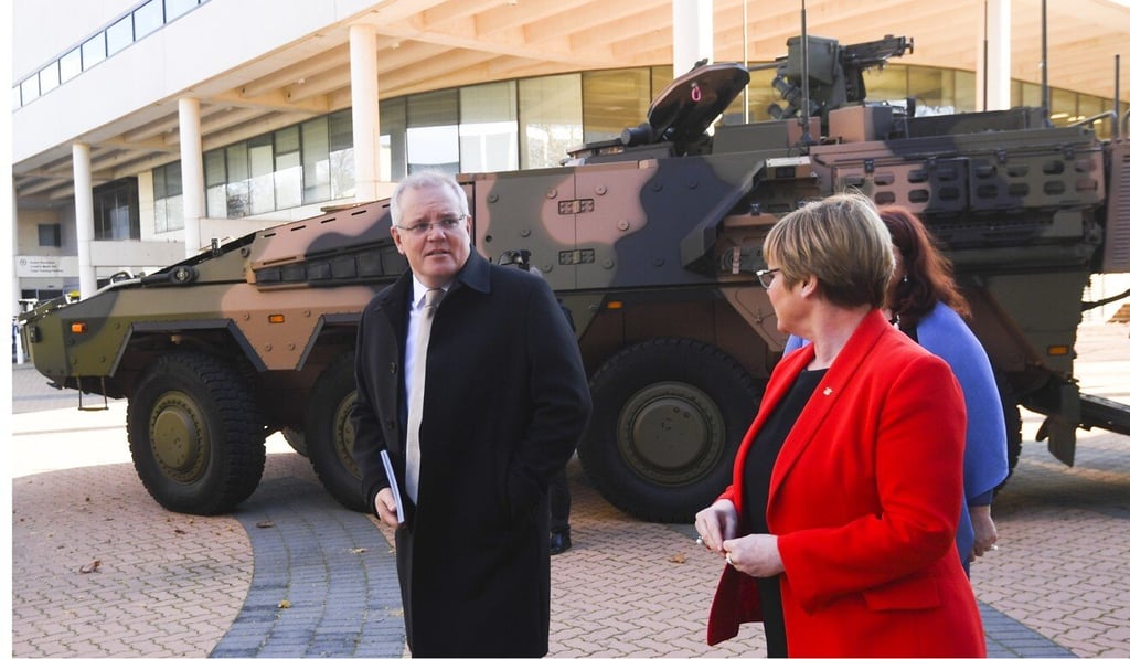 Australian Prime Minister Scott Morrison and Defence Minister Linda Reynolds walk past a Boxer Combat Reconnaissance Vehicle ahead of the launch of the 2020 Defence Strategic Update in Canberra. Photo: EPA-EFE