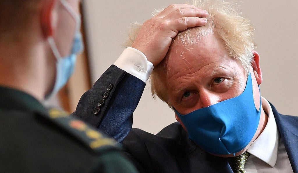 Britain's Prime Minister Boris Johnson wears a mask as he talks to a paramedic during a visit to the headquarters of the London Ambulance Service NHS Trust in London on Monday. Photo: Reuters