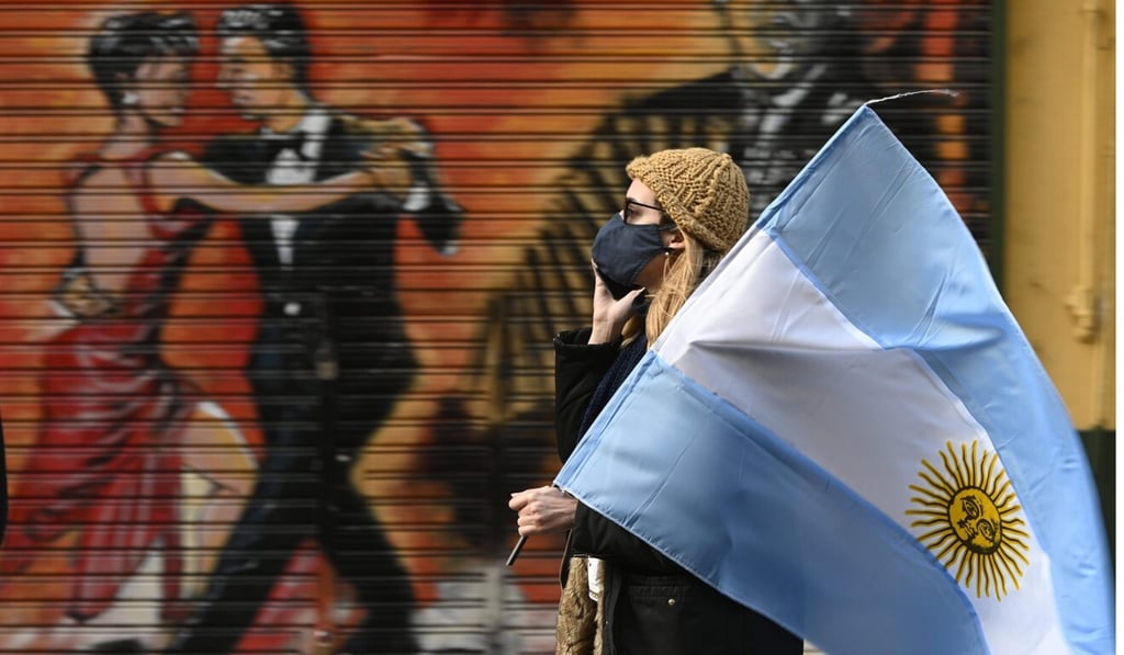 A woman holds an Argentine flag during a protest over lockdown measures in Buenos Aires. Photo: AFP A woman holds an Argentine flag during a protest over lockdown measures in Buenos Aires. Photo: AFP