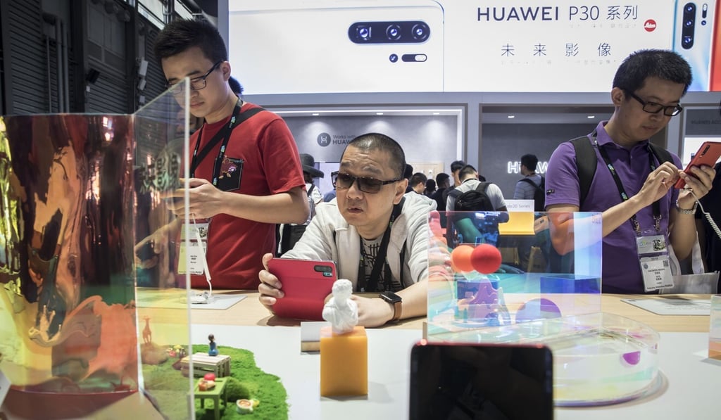 Attendees try out Huawei smartphones on display at the company's exhibition stand during CES Asia 2019. Photo: Bloomberg