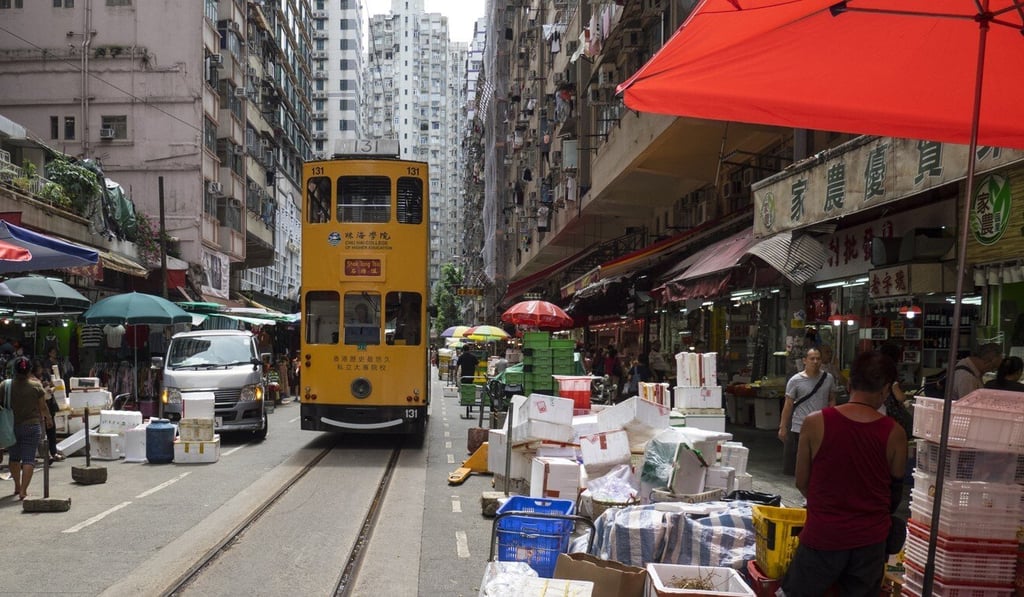 Hong Kong trams pass along Chun Yeung Street, in North Point, which is flanked on both sides by a popular outdoor market selling fresh meat, fish and other produce. Photo: Martin Chan