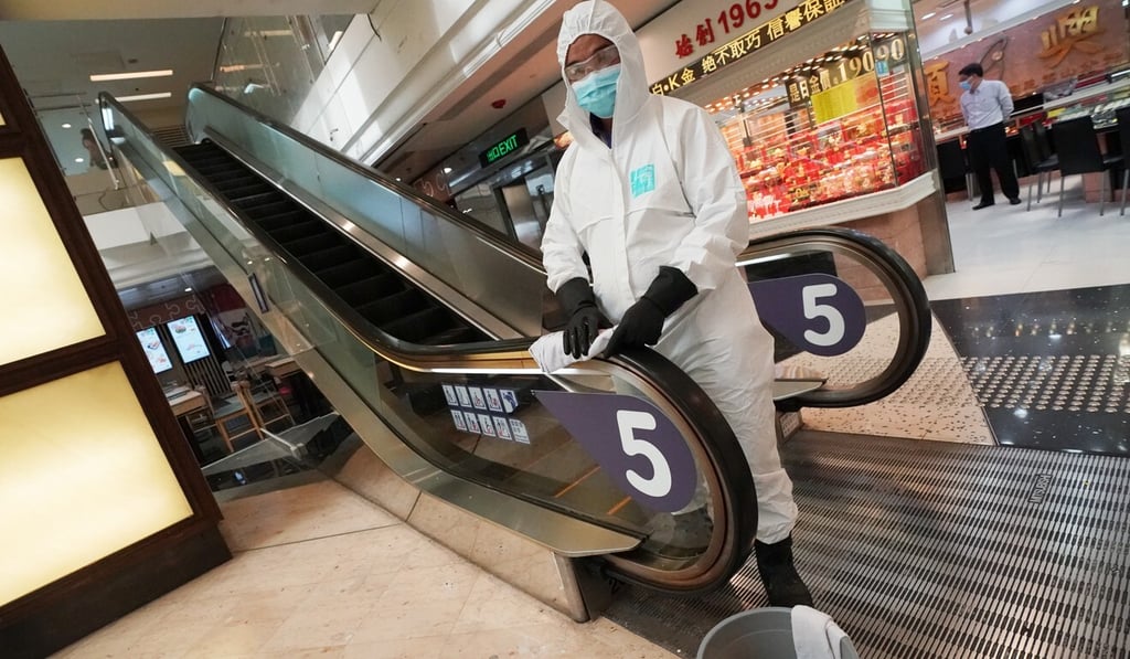 A worker in full protective wear disinfects an escalator handrail in Tsz Wan Shan. Photo: Felix Wong A worker in full protective wear disinfects an escalator handrail in Tsz Wan Shan. Photo: Felix Wong