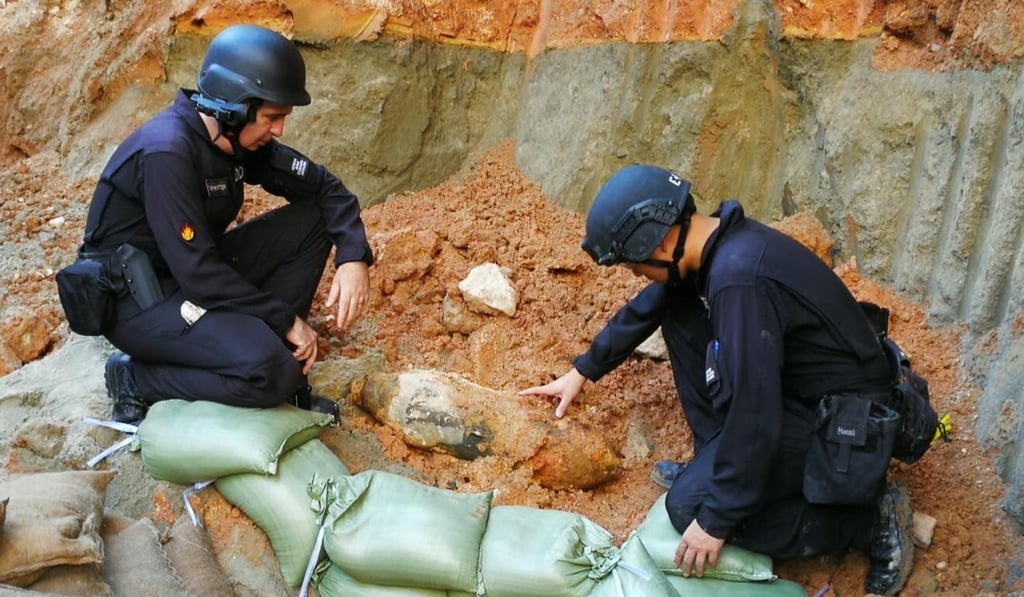 Bomb squad officers study the device found near Kai Tak MTR station. Photo: Handout