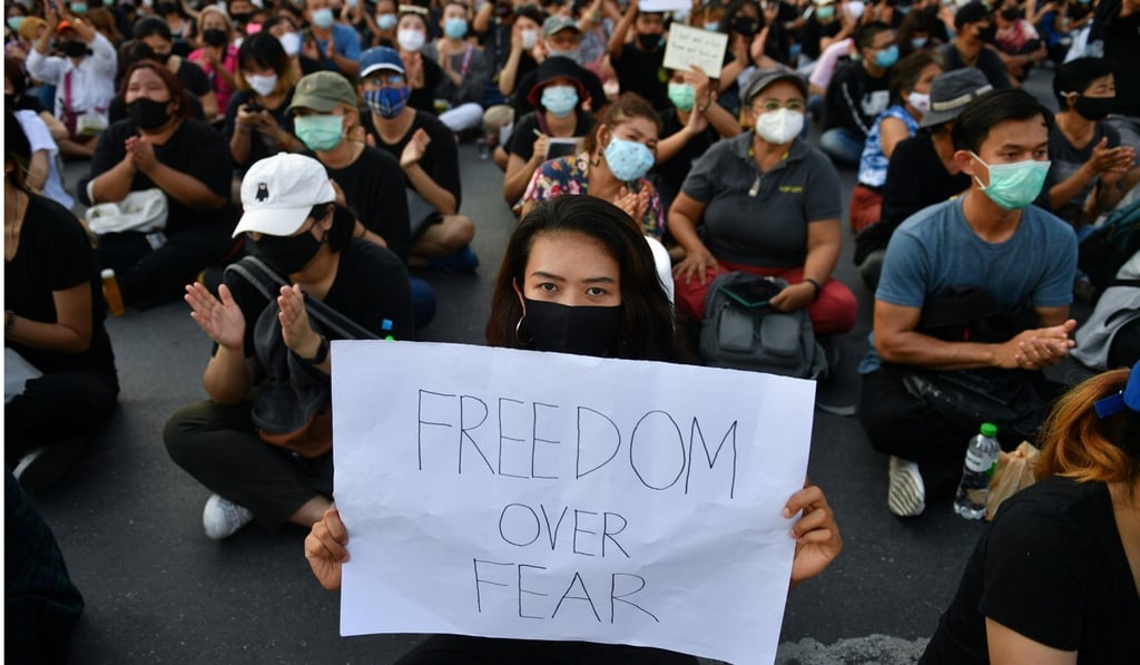 A protester holds a sign during a protest demanding the resignation of the Thai government. Photo: Reuters